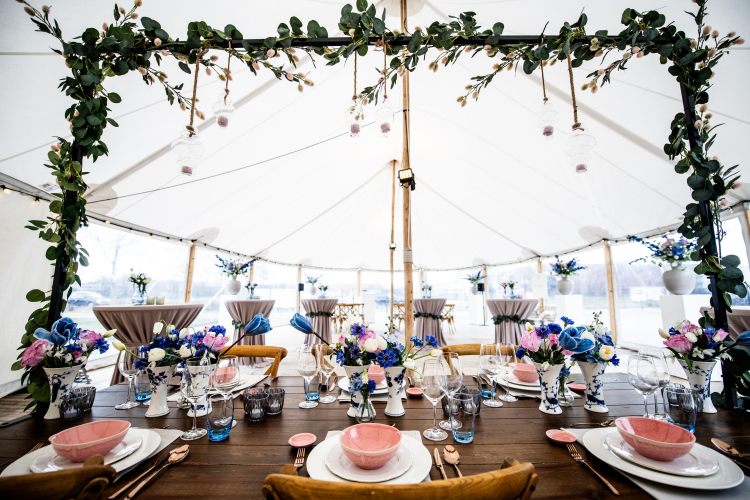 Elegante bruiloftsetting met sfeervol gedecoreerde tafels, bloemen en stijlvolle aankleding – verzorgd door Westerhuis Verhuur
