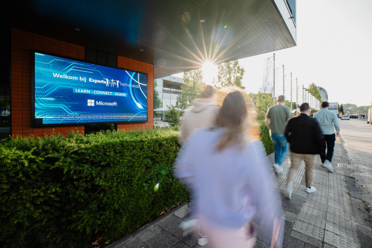 Torenscherm met mensen die naar de entree lopen