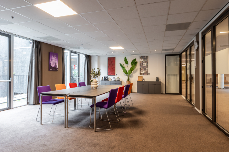 Foto van vergaderruimte met tafel en stoelen