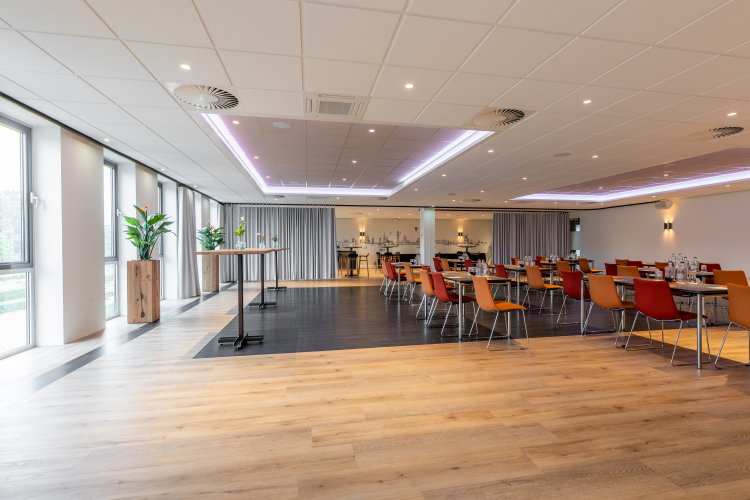 Foto van stoelen en tafels in een vergaderruimte met een gordijn half open 