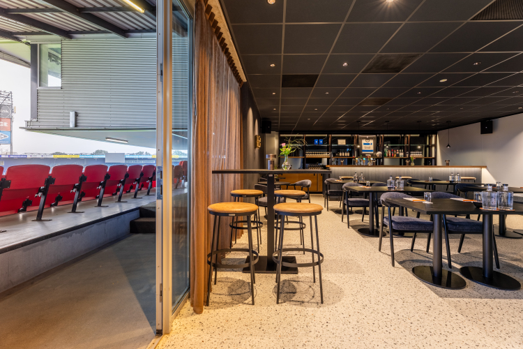 Foto van een skybox in vergaderopstelling en gedeeltelijke tribune zichtbaar