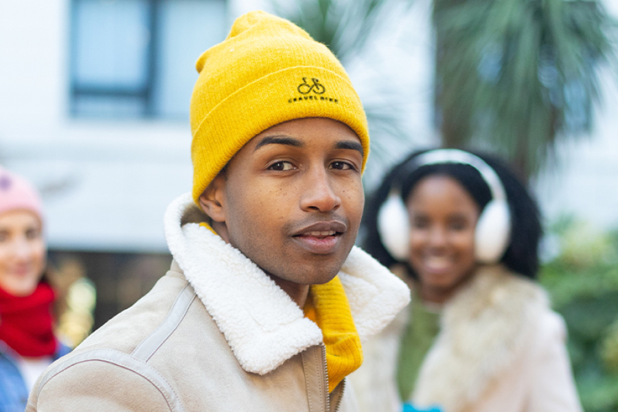 drie werknemers met een muts met logo op