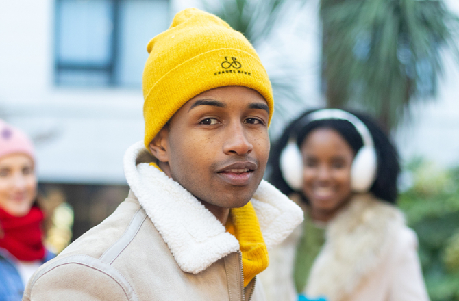 drie werknemers met een muts met logo op
