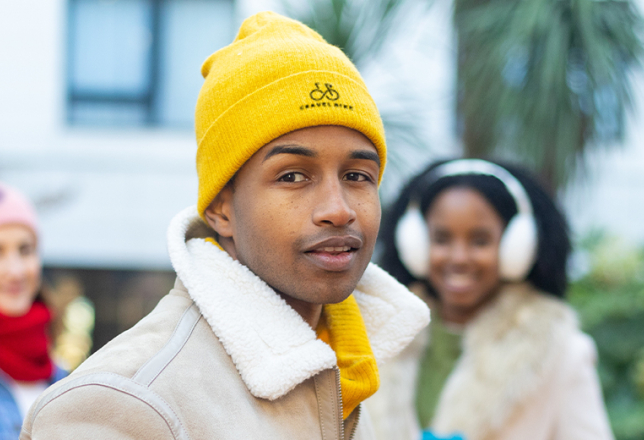 drie werknemers met een muts met logo op
